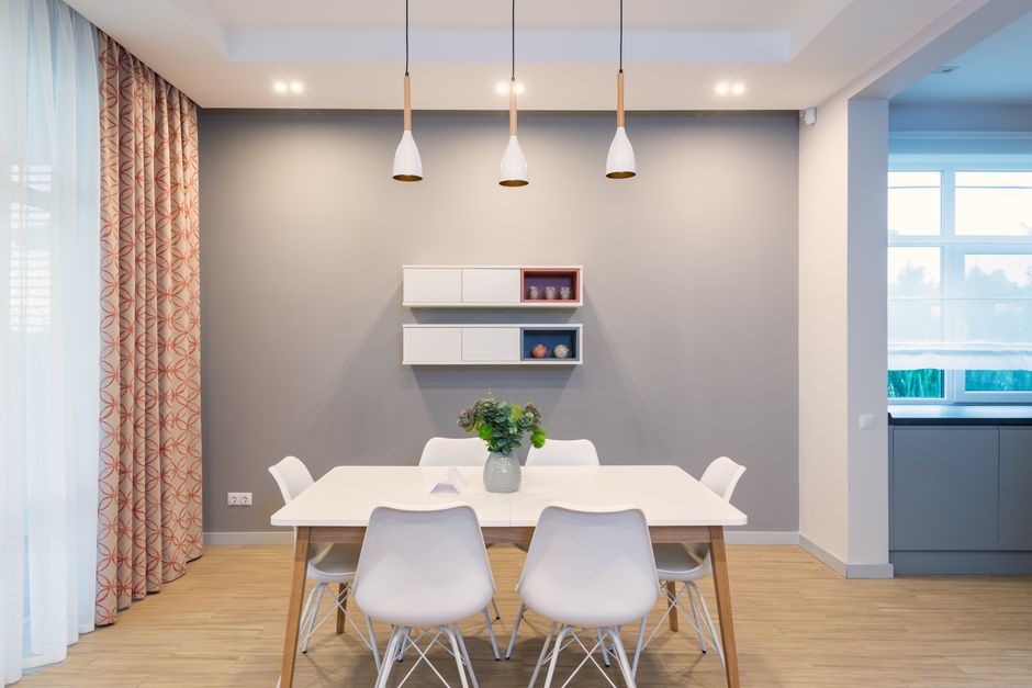 Stijlvolle design hanglampen boven een moderne eettafel in een sfeervolle eetruimte.
